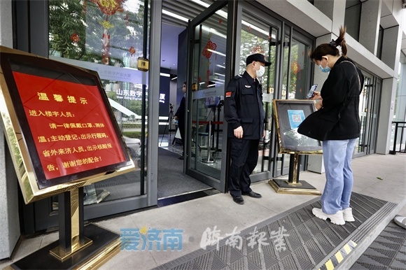 4月26日，在山东数字产业大厦，需要扫码、测体温、查验核酸检测贴方可进入大厦。（赵晓明 摄）