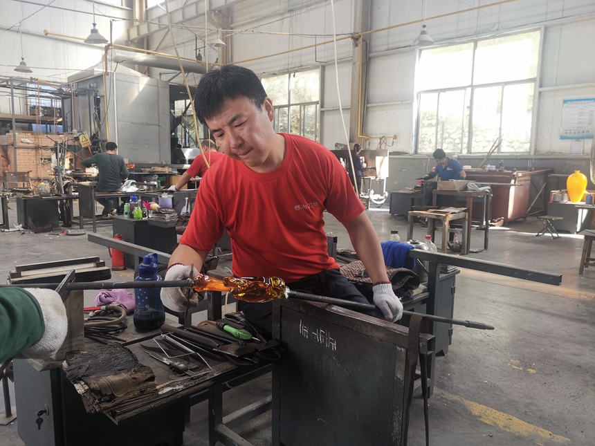 图为山东工艺美术大师刘持君在制作客户定制的琉璃作品。（□记者 赵丰 报道）